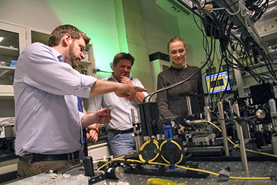 Robert Spekkens, Kevin Resch and Katja Ried examine a quantum optical circuit in the Quantum Optics and Quantum Information Lab at the University of Waterloo